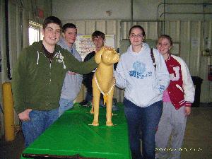 5 teenagers smiling next to a plastic dog